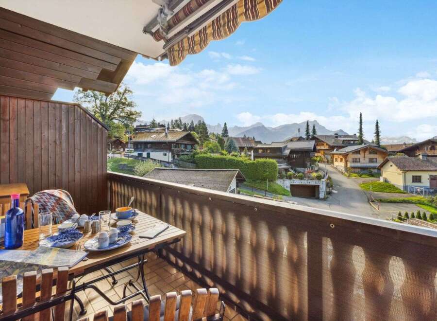 Enjoy breathtaking views from this charming balcony overlooking a picturesque village nestled in the mountains.