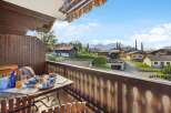 Enjoy breathtaking views from this charming balcony overlooking a picturesque village nestled in the mountains.