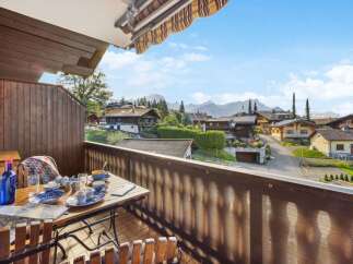 Enjoy breathtaking views from this charming balcony overlooking a picturesque village nestled in the mountains.