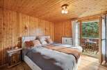 This charming bedroom boasts a warm and inviting ambiance with its wooden walls and ceiling.