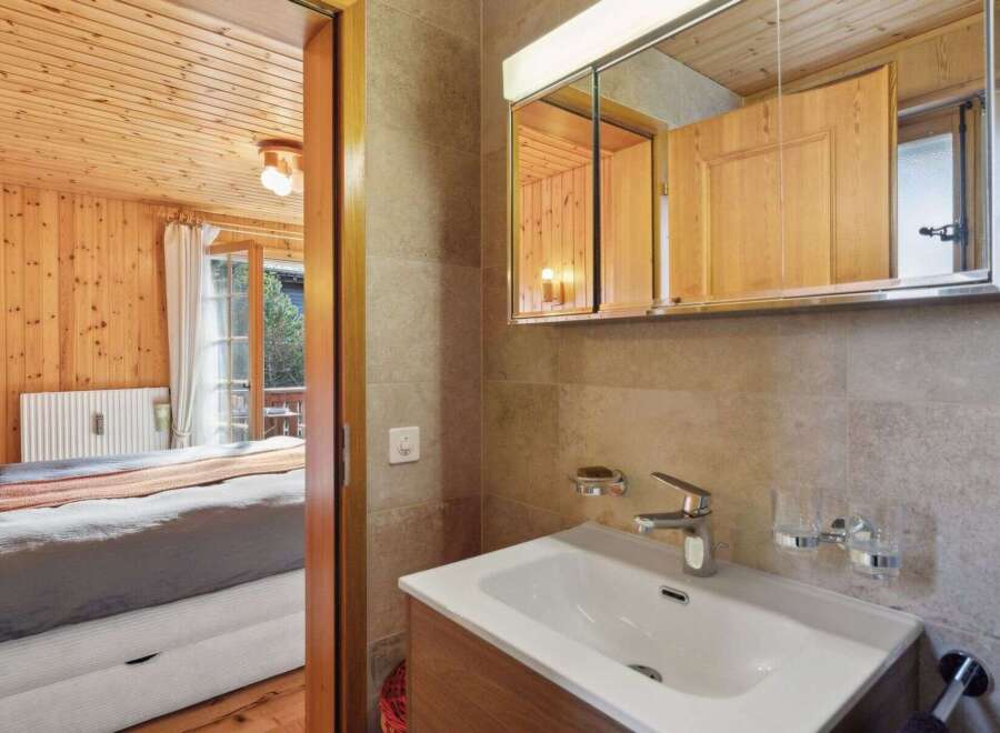 Discover the charm of this cozy property, featuring a beautifully designed bathroom with a modern sink and a stylish mirror.