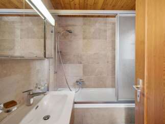 Step into a beautifully designed bathroom featuring a sleek shower enclosure and a modern sink.