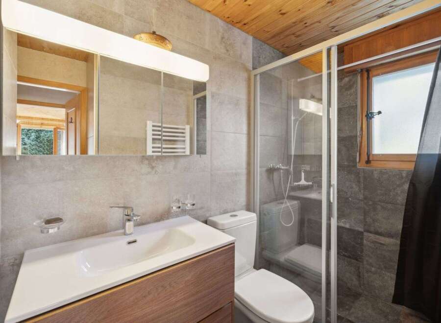 This modern bathroom features a sleek design with a spacious vanity and a contemporary faucet.