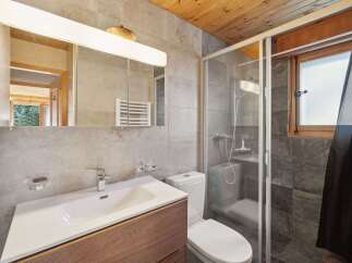 This modern bathroom features a sleek design with a spacious vanity and a contemporary faucet.