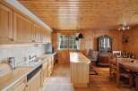 This charming kitchen boasts a warm, inviting atmosphere with its wooden cabinetry and paneling.