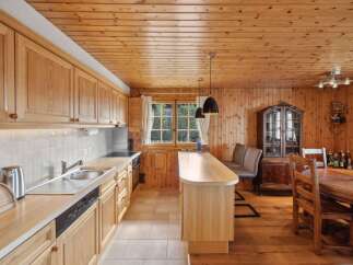 This charming kitchen boasts a warm, inviting atmosphere with its wooden cabinetry and paneling.