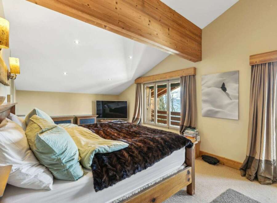 This cozy bedroom features a rustic wooden bed frame and a luxurious faux fur blanket, creating a warm and inviting atmosphere.