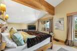 This cozy bedroom features a rustic wooden bed frame and a luxurious faux fur blanket, creating a warm and inviting atmosphere.