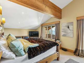 This cozy bedroom features a rustic wooden bed frame and a luxurious faux fur blanket, creating a warm and inviting atmosphere.