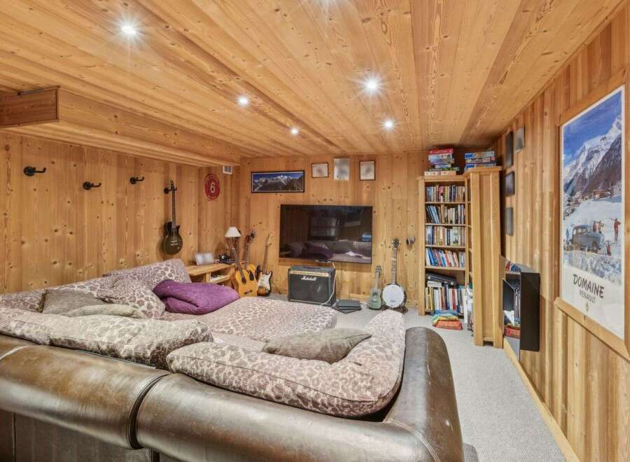 This cozy living space features a warm, inviting ambiance with its wooden paneling and ceiling.