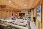 This cozy living space features a warm, inviting ambiance with its wooden paneling and ceiling.
