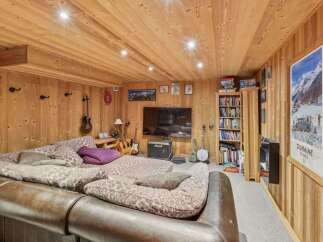 This cozy living space features a warm, inviting ambiance with its wooden paneling and ceiling.