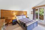 This cozy bedroom features a rustic wooden accent wall and a comfortable bed with a faux fur throw.