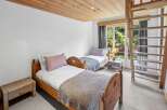 This charming bedroom features two cozy beds with wooden frames, perfect for a comfortable stay.