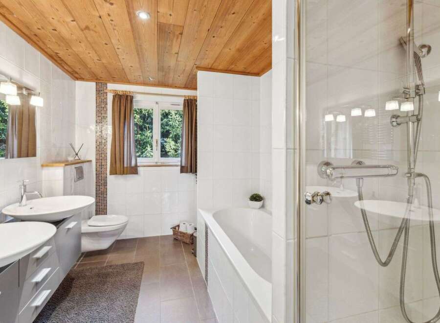 Step into a serene bathroom retreat, featuring a stunning wooden ceiling that adds warmth and character.