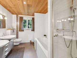 Step into a serene bathroom retreat, featuring a stunning wooden ceiling that adds warmth and character.