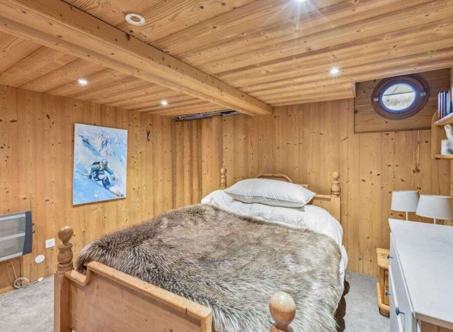 Step into a cozy bedroom retreat featuring rustic wooden accents and a plush, inviting bed.
