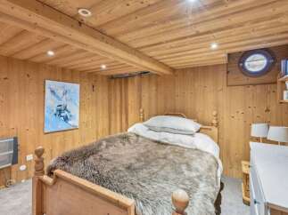 Step into a cozy bedroom retreat featuring rustic wooden accents and a plush, inviting bed.