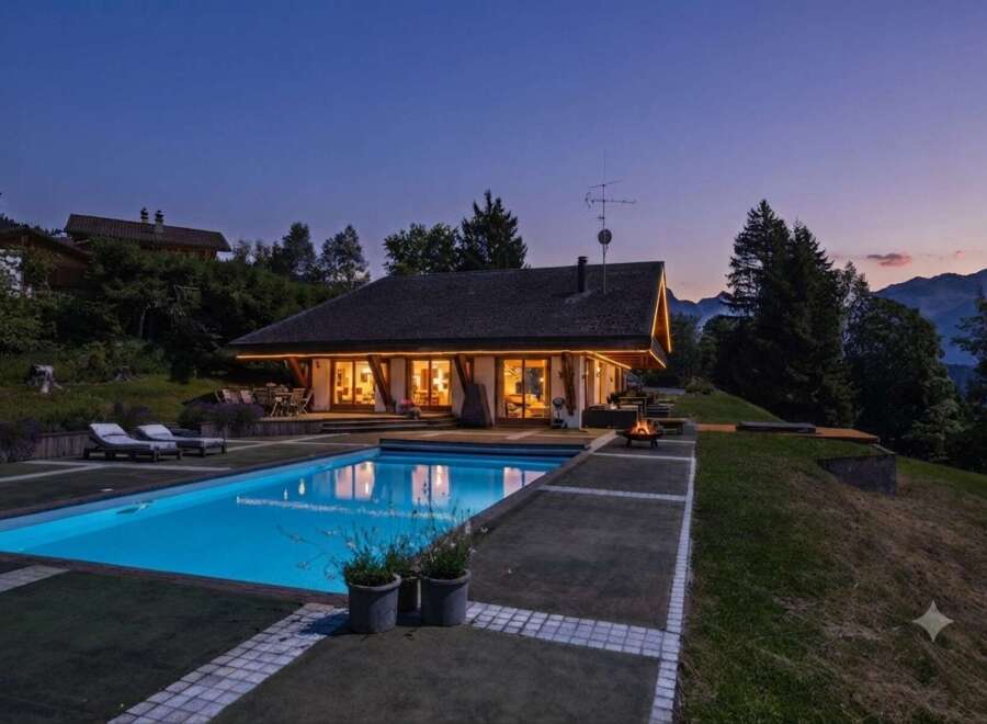 Experience luxury living in this stunning mountain retreat, featuring a pristine swimming pool and a cozy fire pit perfect for evening relaxation.