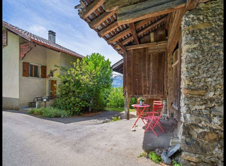Discover the charm of this unique property, featuring a rustic wooden structure and a cozy outdoor seating area.