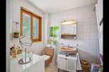 This charming bathroom features a warm, inviting atmosphere with its natural light and neutral color palette.