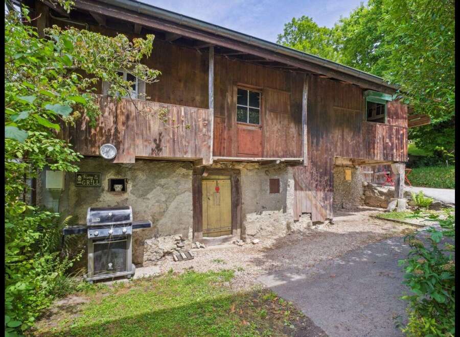 Discover the charm of this unique property featuring a rustic wooden facade and a welcoming outdoor space.