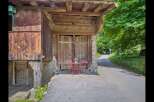 Discover the charm of this unique property, featuring a rustic wooden facade and a welcoming outdoor seating area.