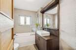 This modern bathroom features a sleek design with a combination of wood and neutral tones.