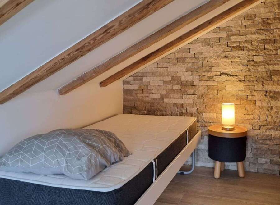Discover a cozy bedroom retreat featuring a comfortable bed and a stylish side table.