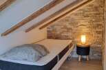 Discover a cozy bedroom retreat featuring a comfortable bed and a stylish side table.