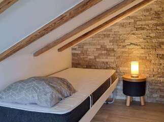 Discover a cozy bedroom retreat featuring a comfortable bed and a stylish side table.