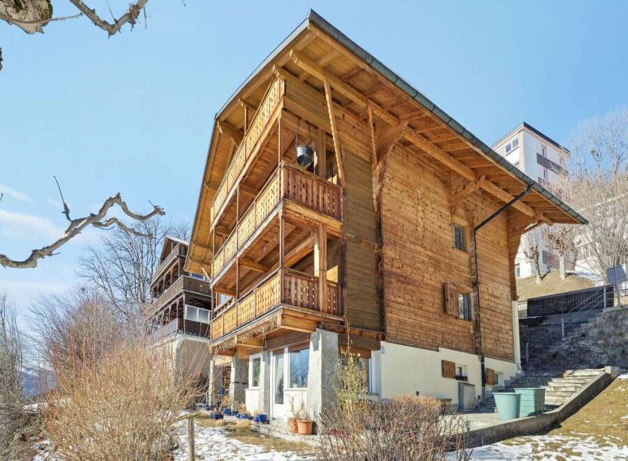 Discover the charm of this stunning wooden chalet, boasting multiple levels of balconies and a warm, inviting facade.