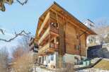 Discover the charm of this stunning wooden chalet, boasting multiple levels of balconies and a warm, inviting facade.