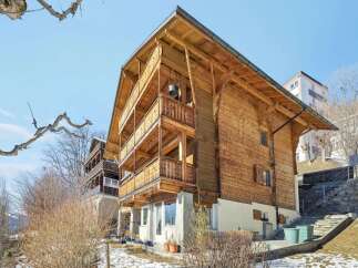 Discover the charm of this stunning wooden chalet, boasting multiple levels of balconies and a warm, inviting facade.
