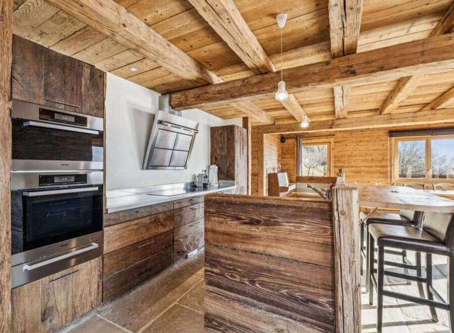 Experience rustic elegance in this stunning kitchen, featuring exposed wooden beams and custom cabinetry.