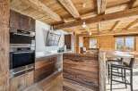 Experience rustic elegance in this stunning kitchen, featuring exposed wooden beams and custom cabinetry.