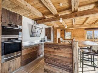 Experience rustic elegance in this stunning kitchen, featuring exposed wooden beams and custom cabinetry.