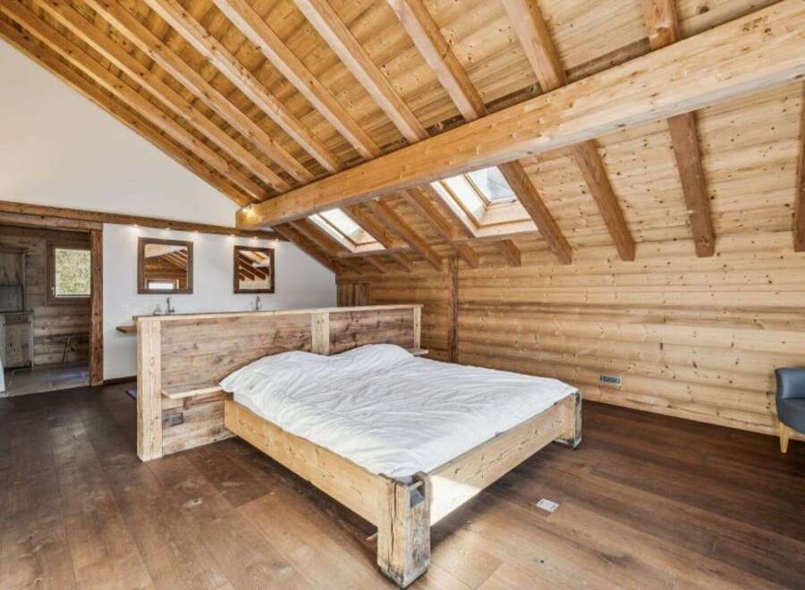 Experience rustic elegance in this stunning bedroom featuring exposed wooden beams and a cozy atmosphere.
