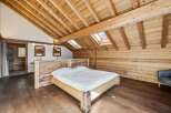 Experience rustic elegance in this stunning bedroom featuring exposed wooden beams and a cozy atmosphere.