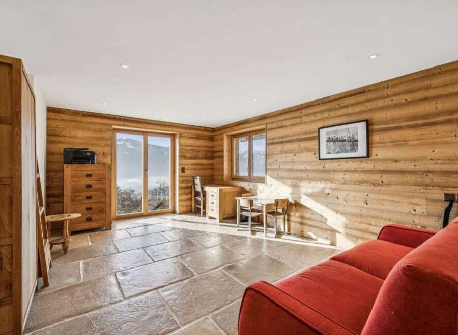 Experience the charm of this stunning property, featuring a cozy living space with natural wood paneling and a rustic stone floor.