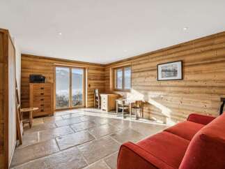 Experience the charm of this stunning property, featuring a cozy living space with natural wood paneling and a rustic stone floor.