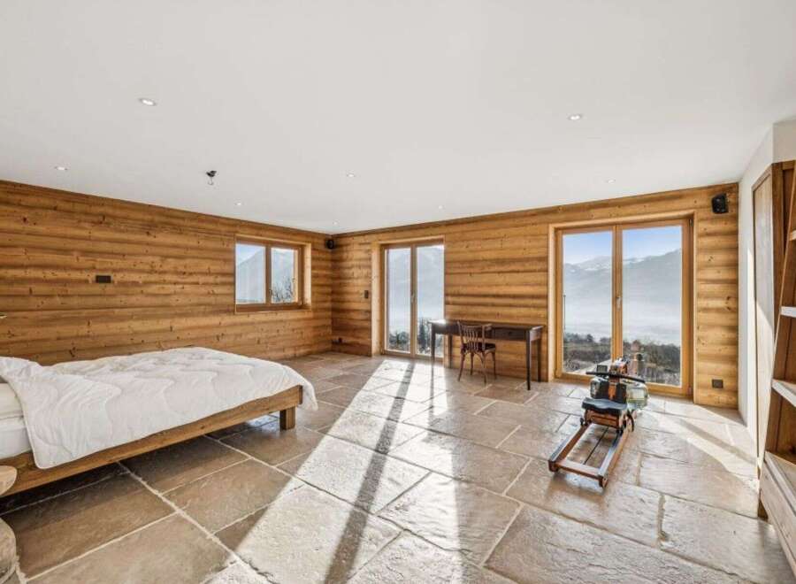 Experience luxury living in this stunning property, featuring a spacious bedroom with breathtaking mountain views.