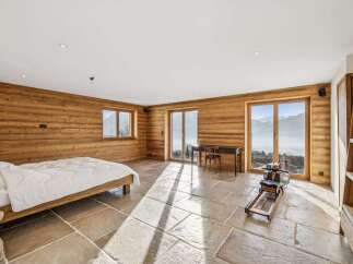 Experience luxury living in this stunning property, featuring a spacious bedroom with breathtaking mountain views.