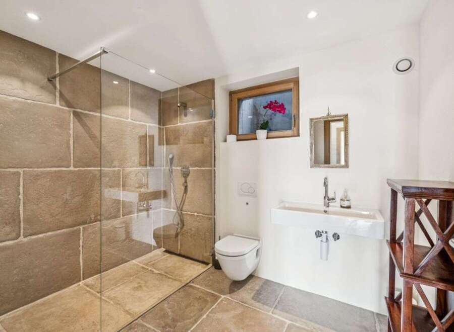 Step into luxury with this stunning bathroom featuring a walk-in shower with a glass enclosure.