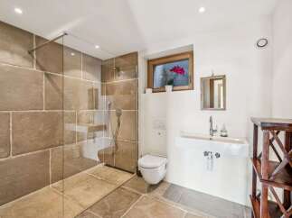 Step into luxury with this stunning bathroom featuring a walk-in shower with a glass enclosure.