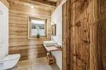 This stunning bathroom showcases rustic charm with its wooden walls and door, creating a warm and inviting atmosphere.