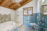 Experience luxury in this stunning bathroom featuring a unique pebble stone design and a modern glass shower.