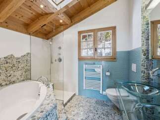 Experience luxury in this stunning bathroom featuring a unique pebble stone design and a modern glass shower.