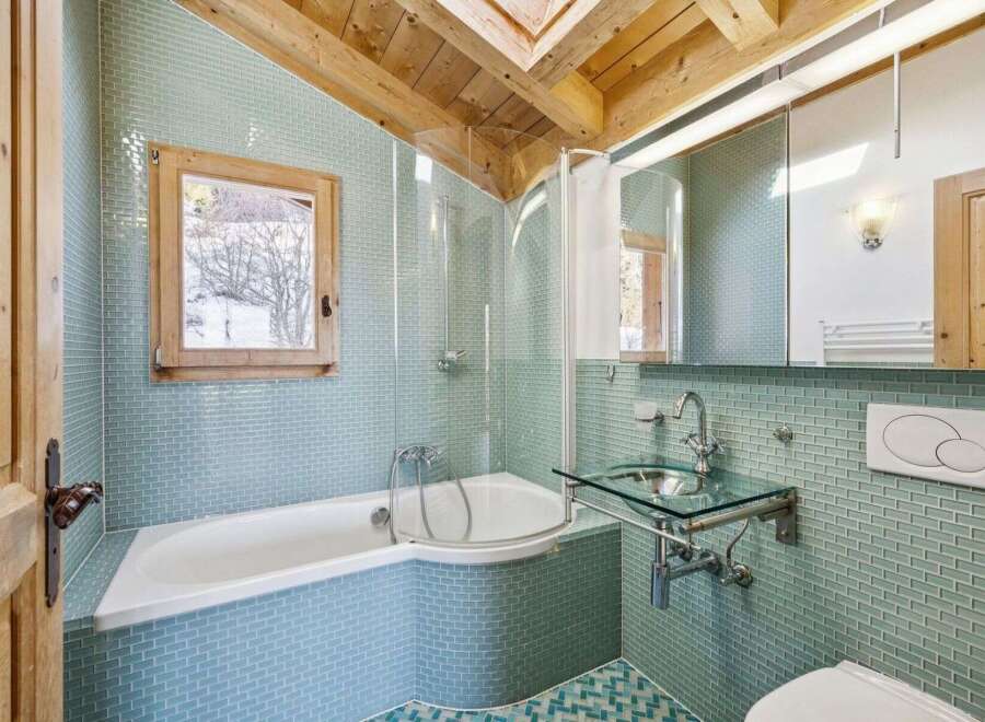 Step into this stunning bathroom, featuring a unique design with a corner bathtub and a glass sink.