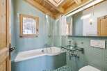 Step into this stunning bathroom, featuring a unique design with a corner bathtub and a glass sink.
